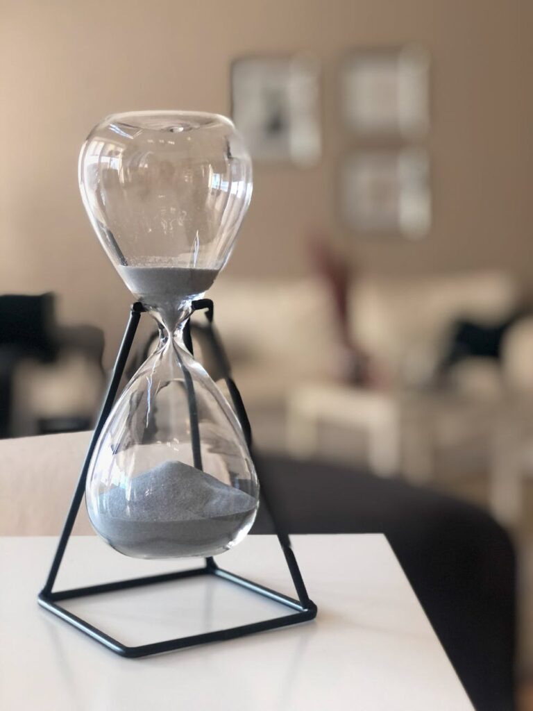 clear glass hour glass on black metal frame